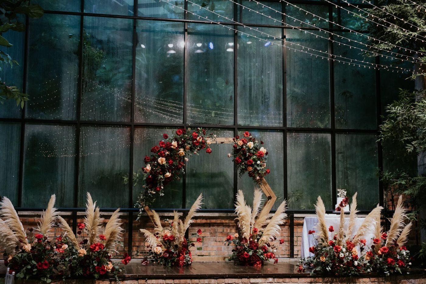 Greenhouse stage with a floral arch and pampas grass